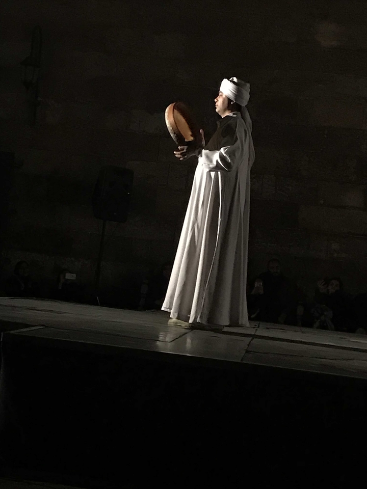 Personne en robe blanche se produisant la nuit.