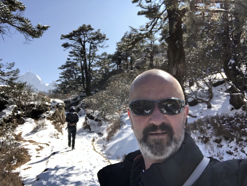 Deux personnes faisant de la randonnée dans un paysage enneigé avec des montagnes.