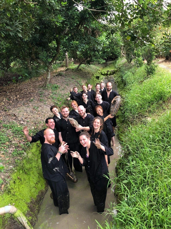 Groupe de personnes dans une zone boueuse profitant d'une activité de plein air.