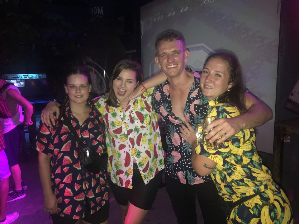 Groupe de personnes en chemises colorées posant dans un cadre intérieur.