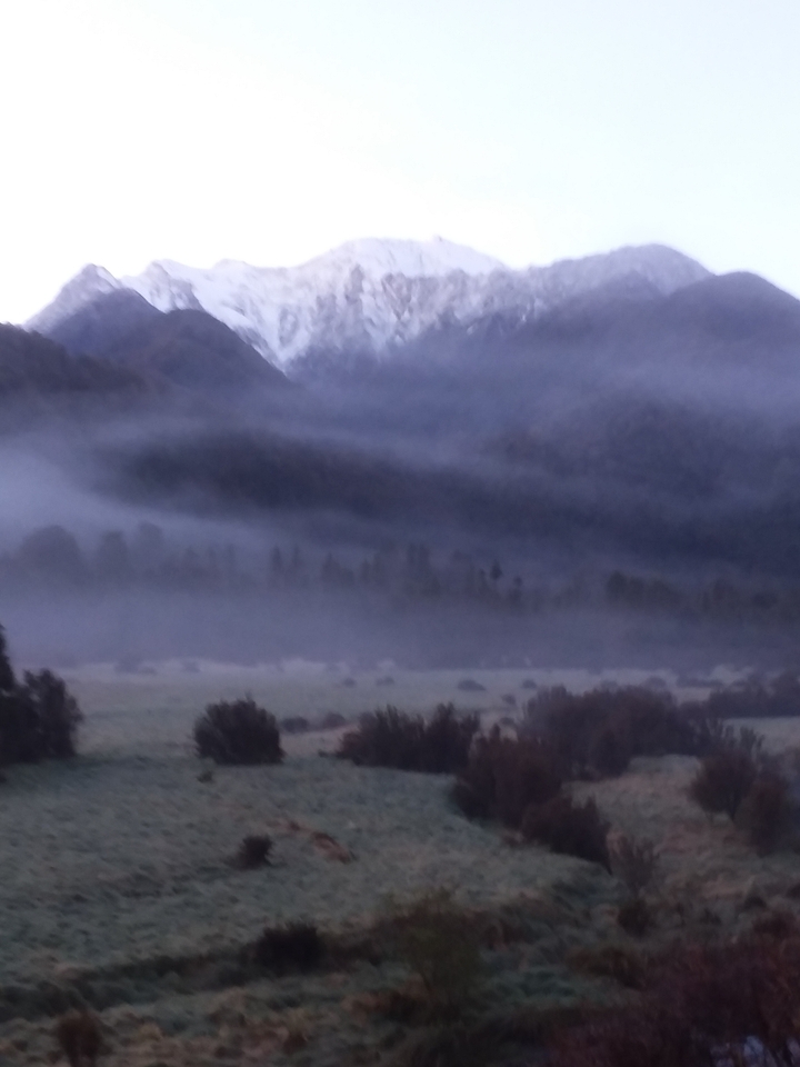 Foggy landscape with faint mountain silhouettes.