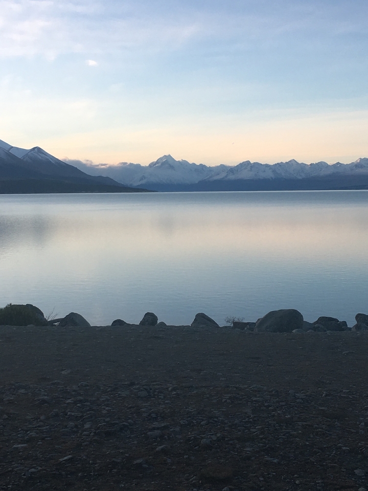 Lac calme avec des montagnes se reflétant à sa surface.