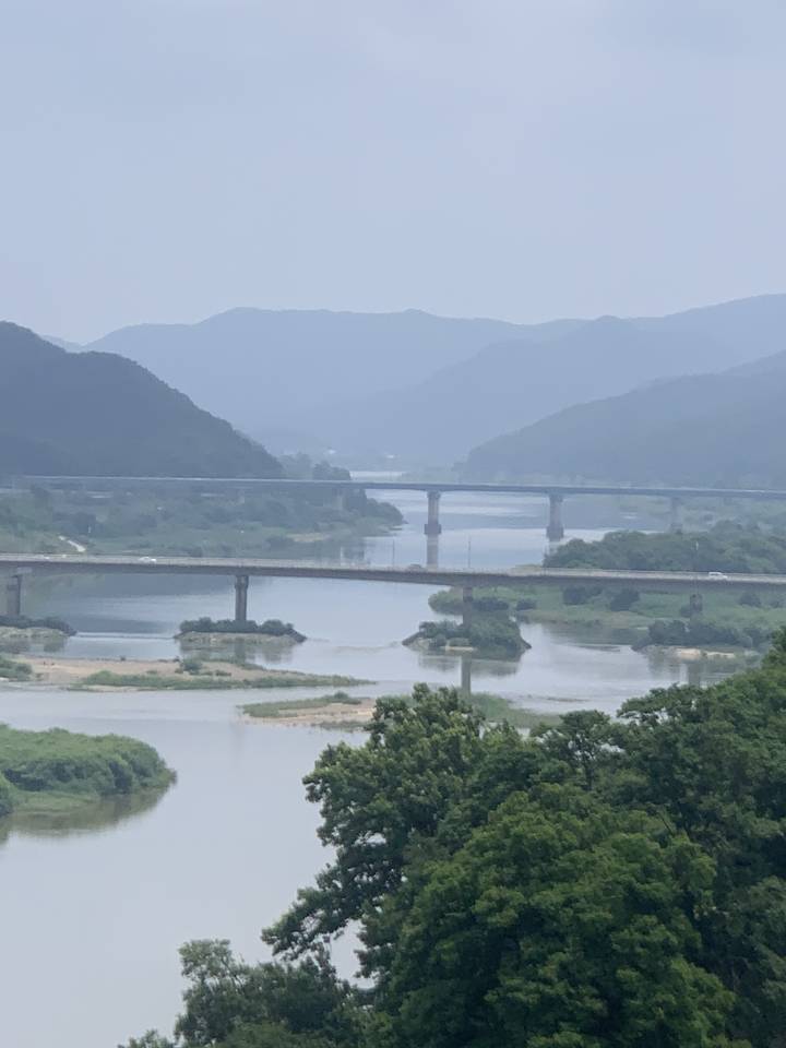 Vue panoramique avec une rivière, des montagnes et des ponts.