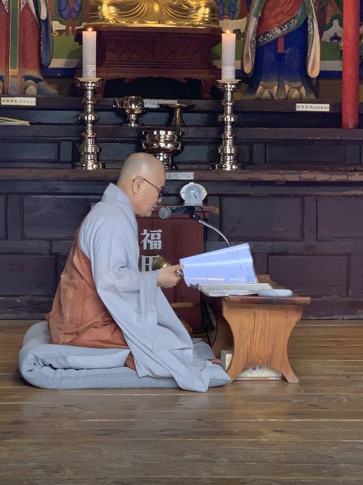 Personne à l'intérieur d'un temple, pratiquant la méditation ou la prière.