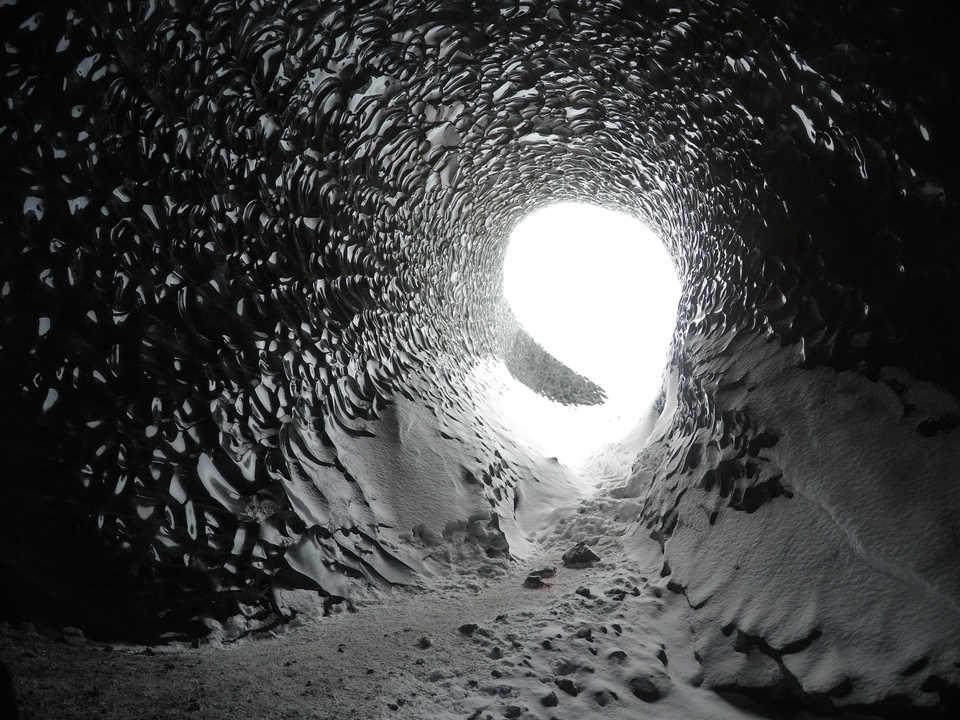 Ouverture ronde de grotte de glace avec stalactites de glace.