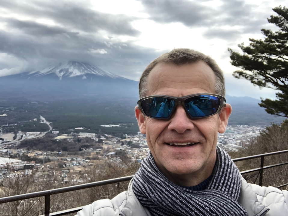Personne souriante avec le mont Fuji en arrière-plan.