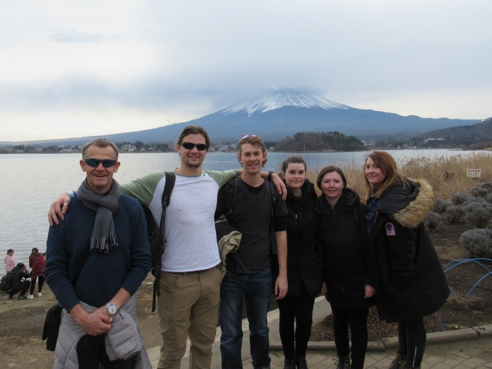 Groupe de personnes posant avec une vue de montagne lointaine.
