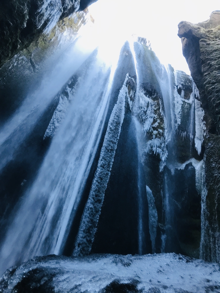 Close-up of a partially frozen waterfall in winter.