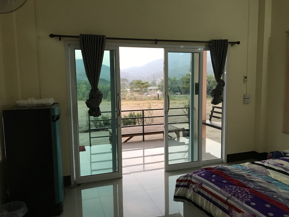 Vue depuis une pièce avec des portes vitrées donnant sur un paysage.