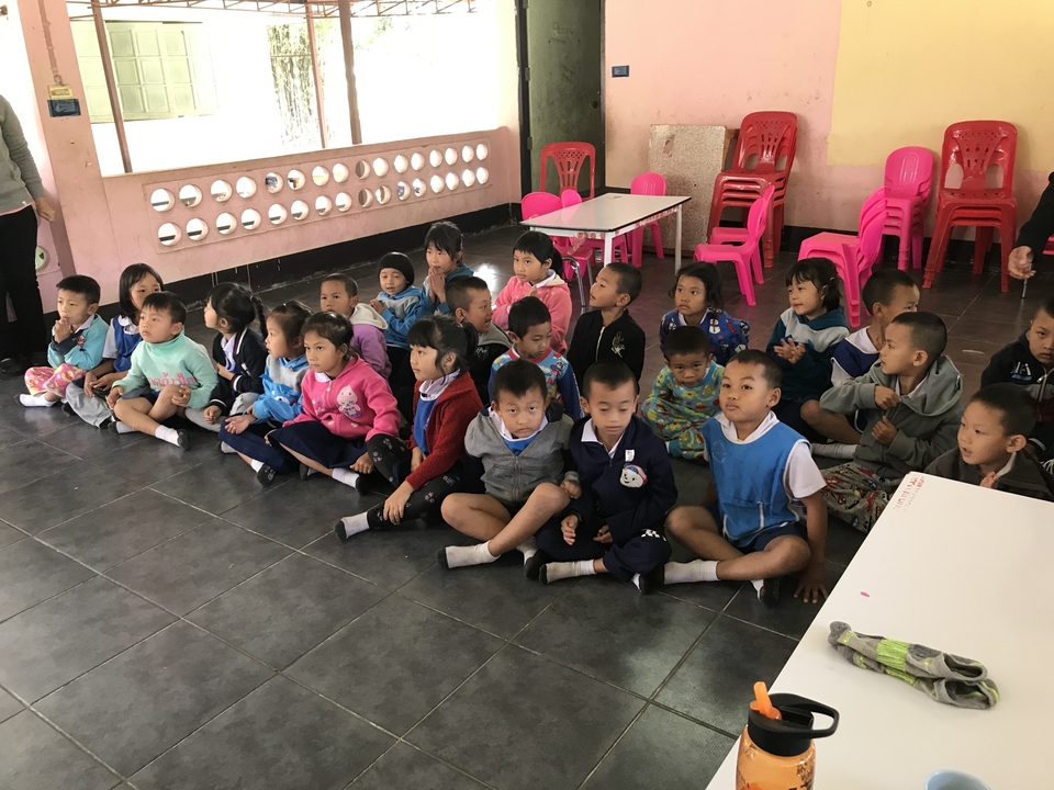 Un groupe de jeunes enfants assis dans une salle de classe.