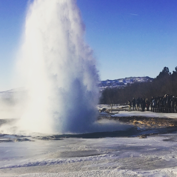 Éruption de geyser avec des gens qui regardent.
