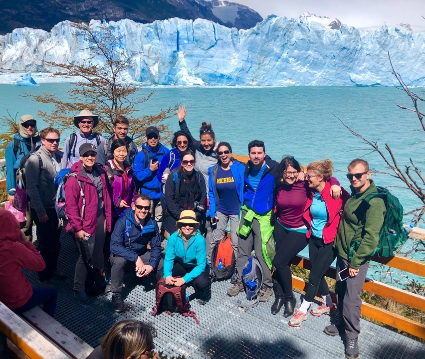 Groupe de personnes avec un glacier et de l'eau bleue en arrière-plan.