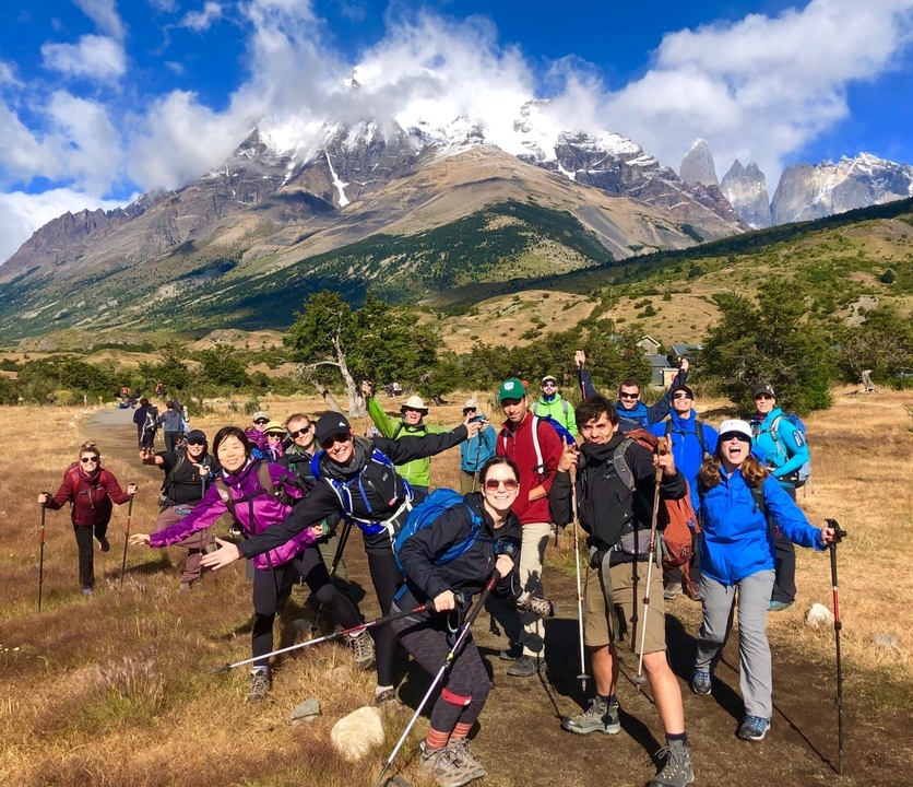 Groupe de randonneurs posant devant d'impressionnantes montagnes.