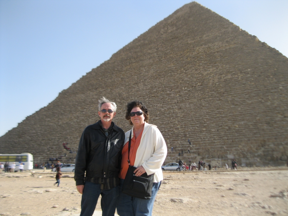 Couple debout devant une grande pyramide.
