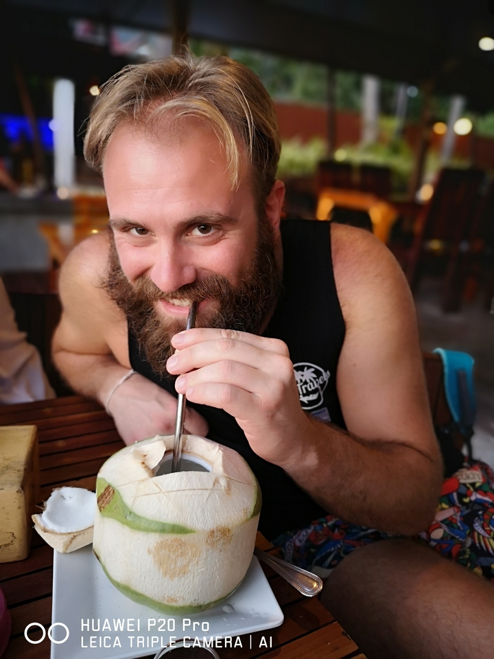 Person drinking from a coconut.