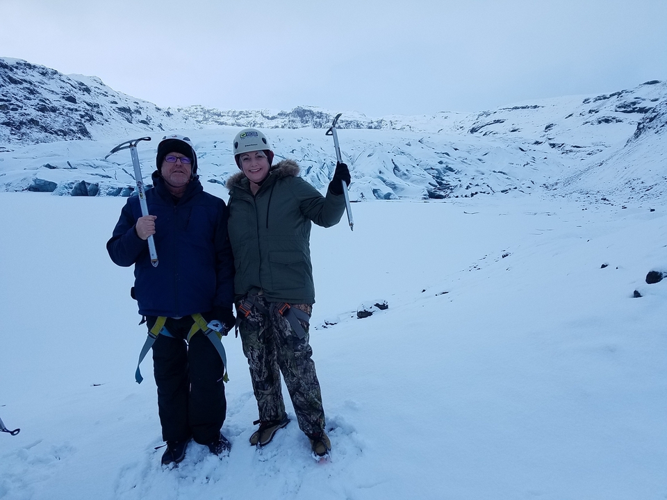 Deux personnes posant avec du matériel d'escalade sur glace dans un paysage enneigé.