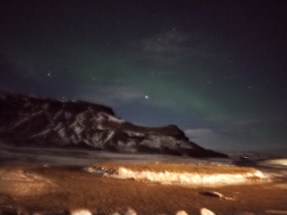 Ciel nocturne flou avec aurores boréales visibles.