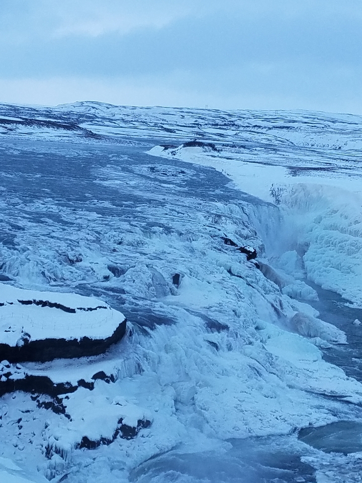 Frozen waterfall with heavy ice formations around it.