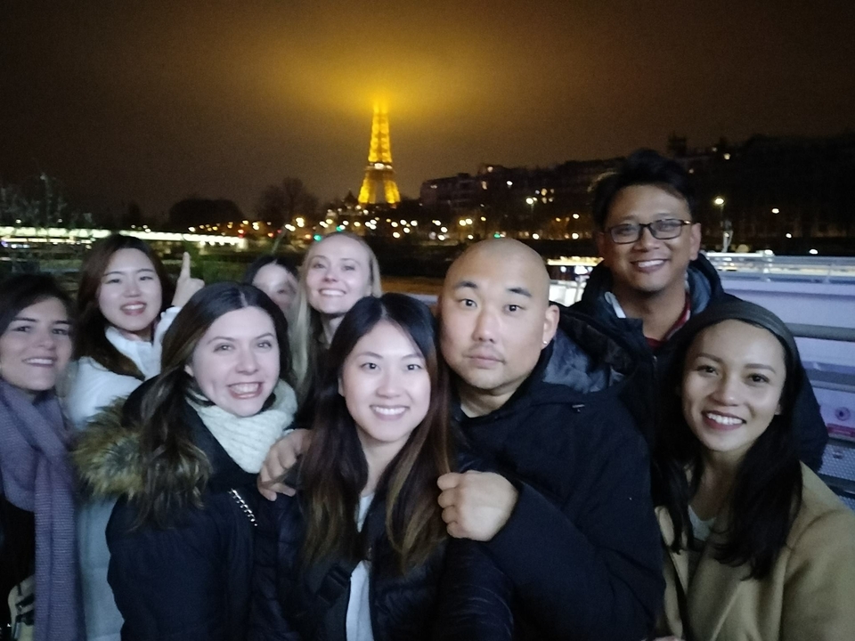 Groupe de personnes avec la tour Eiffel illuminée en arrière-plan.