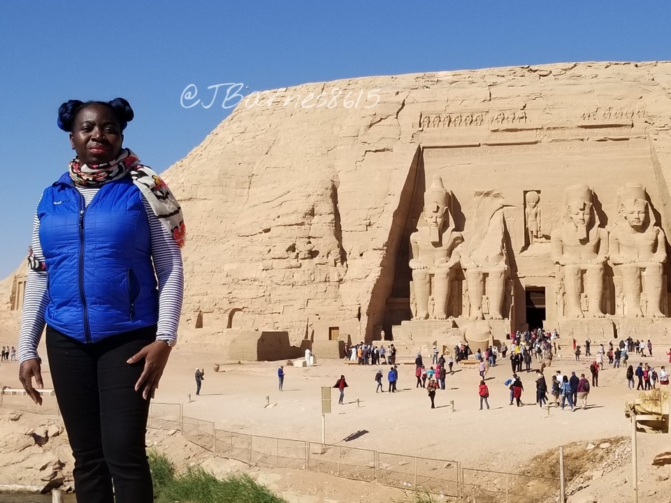 Femme posant devant Abou Simbel avec texte en surimpression.