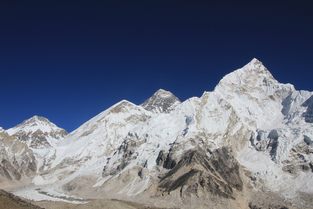 Gros plan de montagnes avec des pics proéminents sur un ciel bleu dégagé.