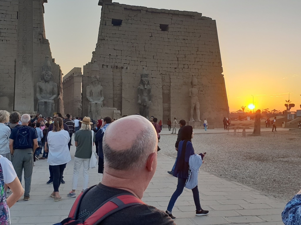Touristes visitant les ruines de l'Égypte ancienne au coucher du soleil