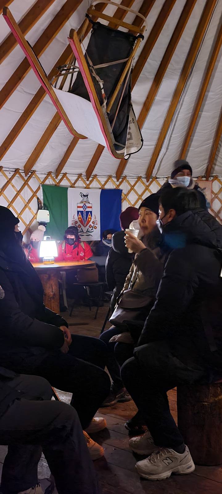 Des gens assis à l'intérieur d'une yourte en train de discuter.