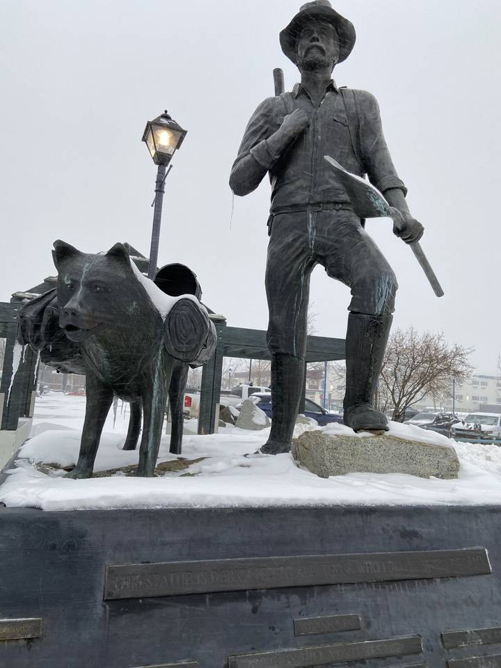 Statue de bronze d'un personnage historique dans un décor hivernal.