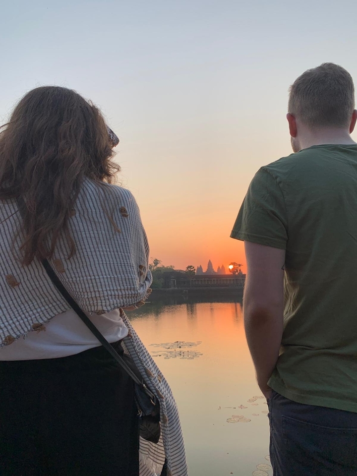 Deux personnes admirant le coucher de soleil à Angkor Vat.