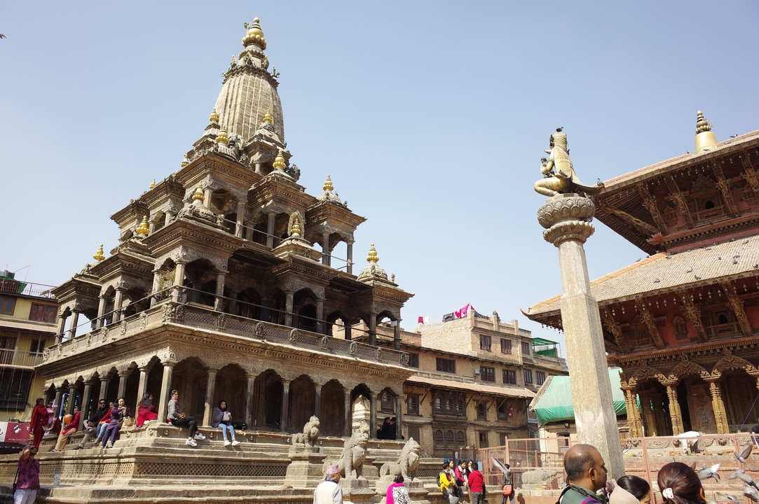 Place Durbar de Katmandou avec des bâtiments historiques et des gens assis à proximité.