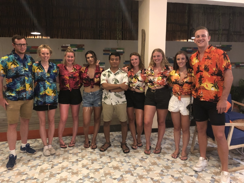 Un groupe de personnes en chemises colorées assorties posant à l'intérieur.