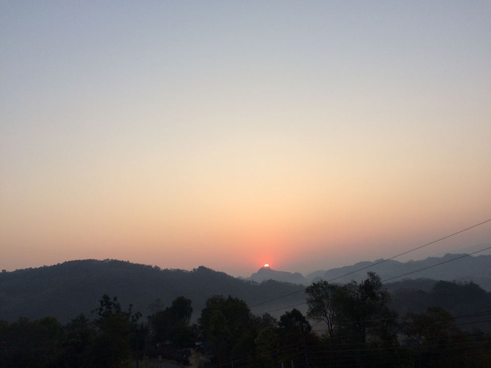 Vue du coucher de soleil sur les collines avec un ciel dégagé.