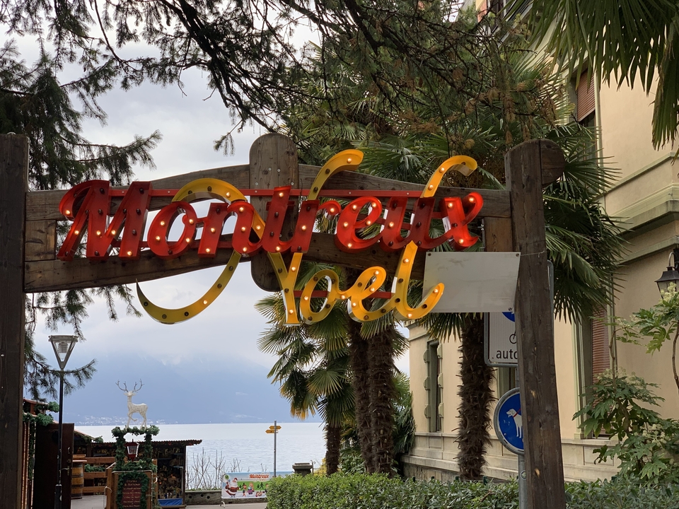 Panneau festif Montreux Noël avec vue lointaine sur un plan d'eau.