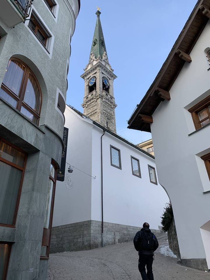 Église avec un haut clocher et des bâtiments.
