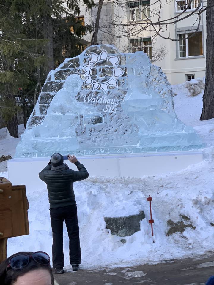 Personne prenant une photo d'une sculpture de glace avec un motif floral.