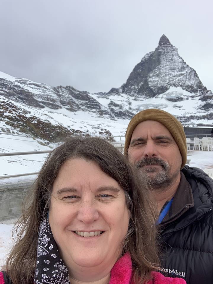 Selfie avec deux personnes et une montagne enneigée en arrière-plan.