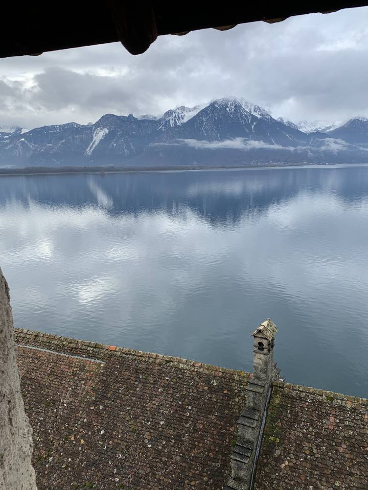 Lac avec montagnes et reflets de nuages visibles.