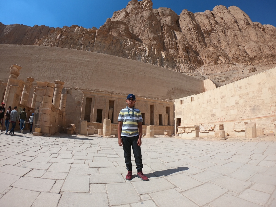 Jeune personne debout devant des ruines égyptiennes