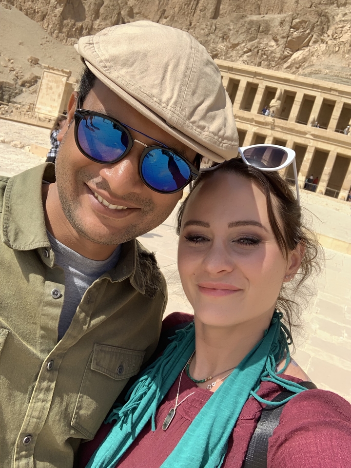 Selfie d'un couple avec une structure ancienne en arrière-plan.