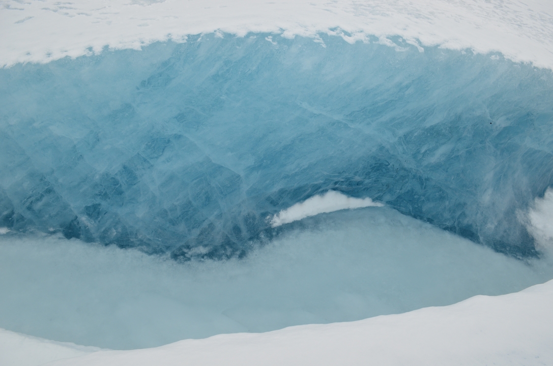 Gros plan de glace bleue transparente dans une crevasse de glacier.
