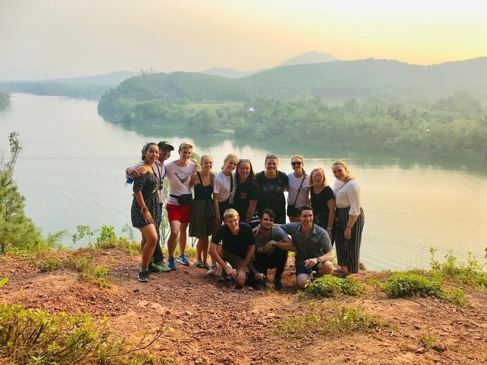 Groupe de personnes avec vue sur le lac au coucher du soleil.