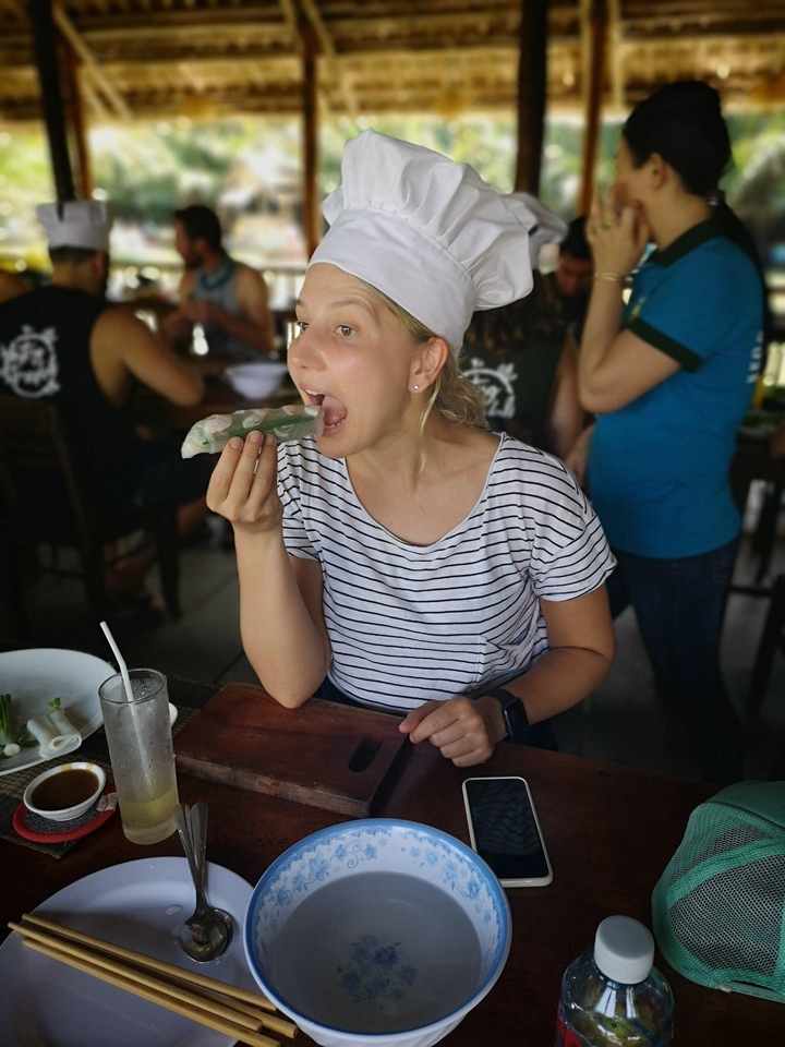 Femme savourant un rouleau de printemps vietnamien dans un restaurant.