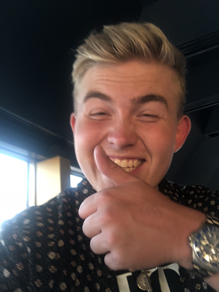 A man giving a thumbs-up gesture, smiling.