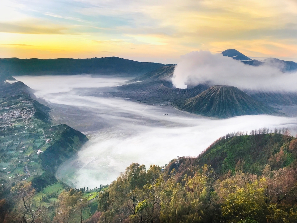 Vue aérienne d'un cratère avec de la brume et de la fumée.