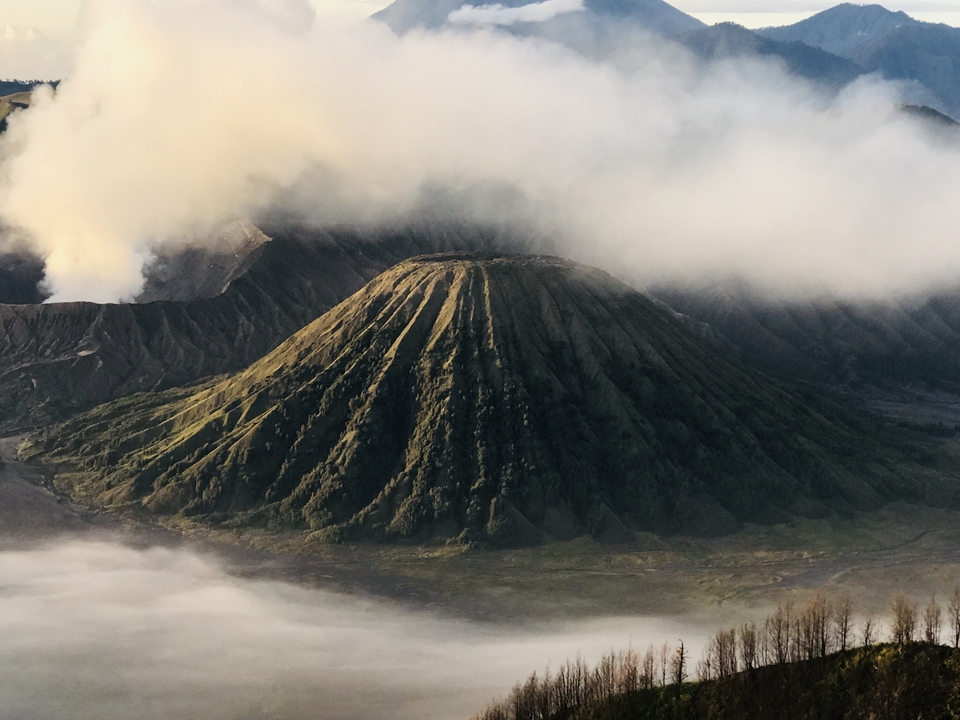 Vue panoramique du mont Bromo avec des nuages au-dessus.