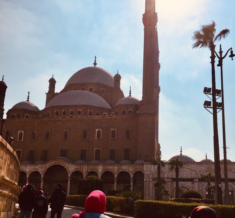 Mosquée historique avec des dômes et un minaret sous un ciel bleu.