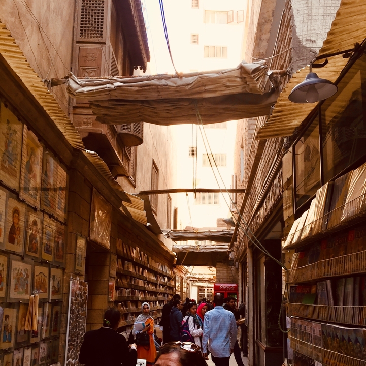 Ruelle étroite et sinueuse avec des livres et des affiches.