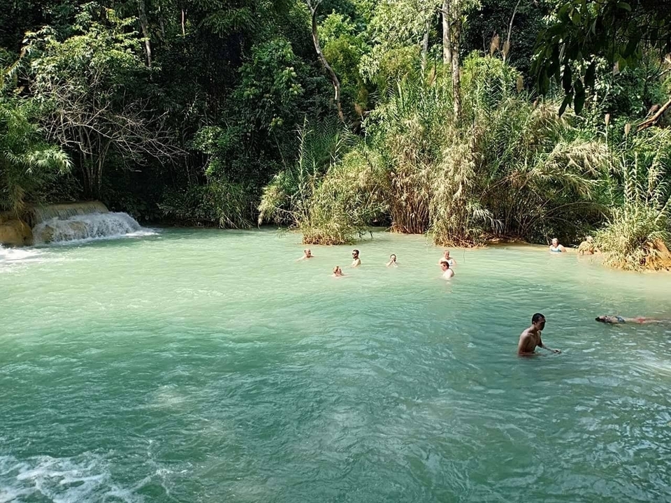 Des gens qui nagent dans une eau turquoise claire.