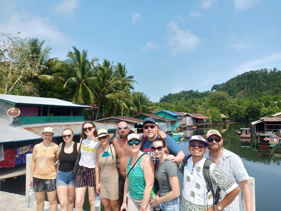 Photo de groupe dans un village au bord de l'eau.