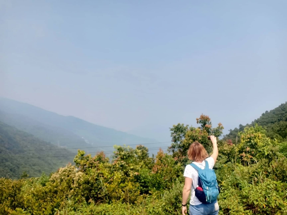Personne avec un sac à dos regardant un paysage vallonné.